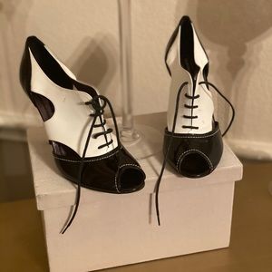 Black and white spectator peep toe pumps.
